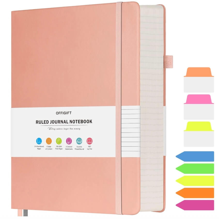 “Pink vegan leather A5 ruled journal notebook with 312 pages, elastic band closure, ribbon bookmark, pen holder, and colorful index stickers.”