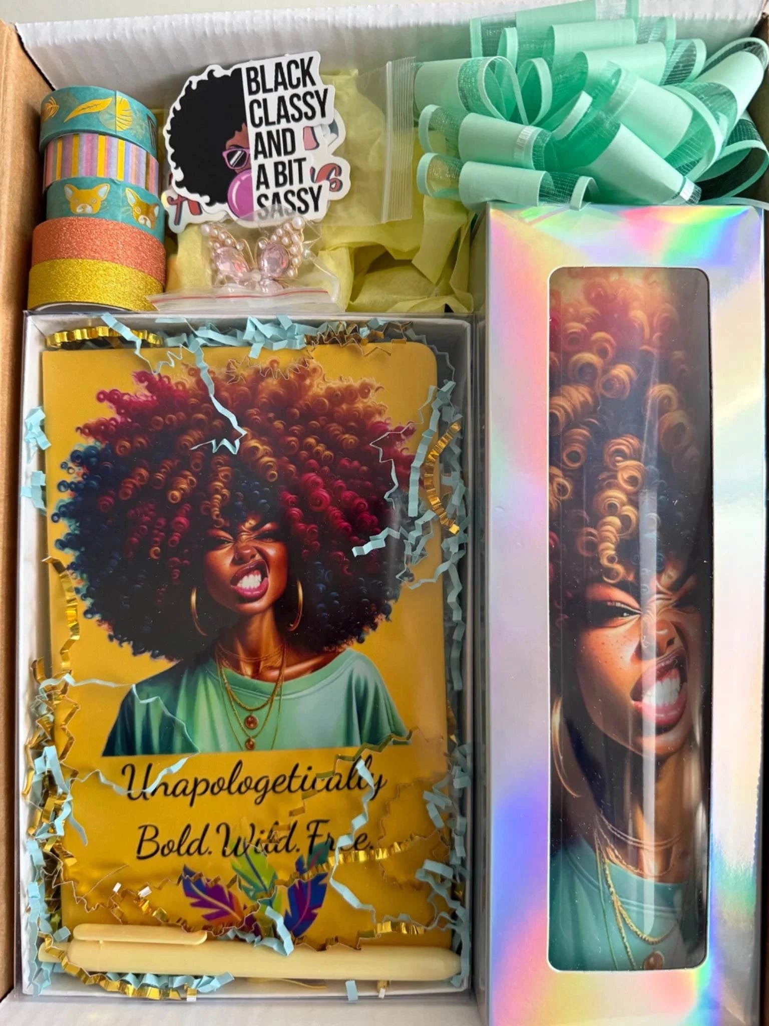 “Unapologetically Her luxury gift box set featuring bold afro-inspired journal, matching insulated tumbler, stickers, washi tape, and premium gift packaging with bow and filler.”