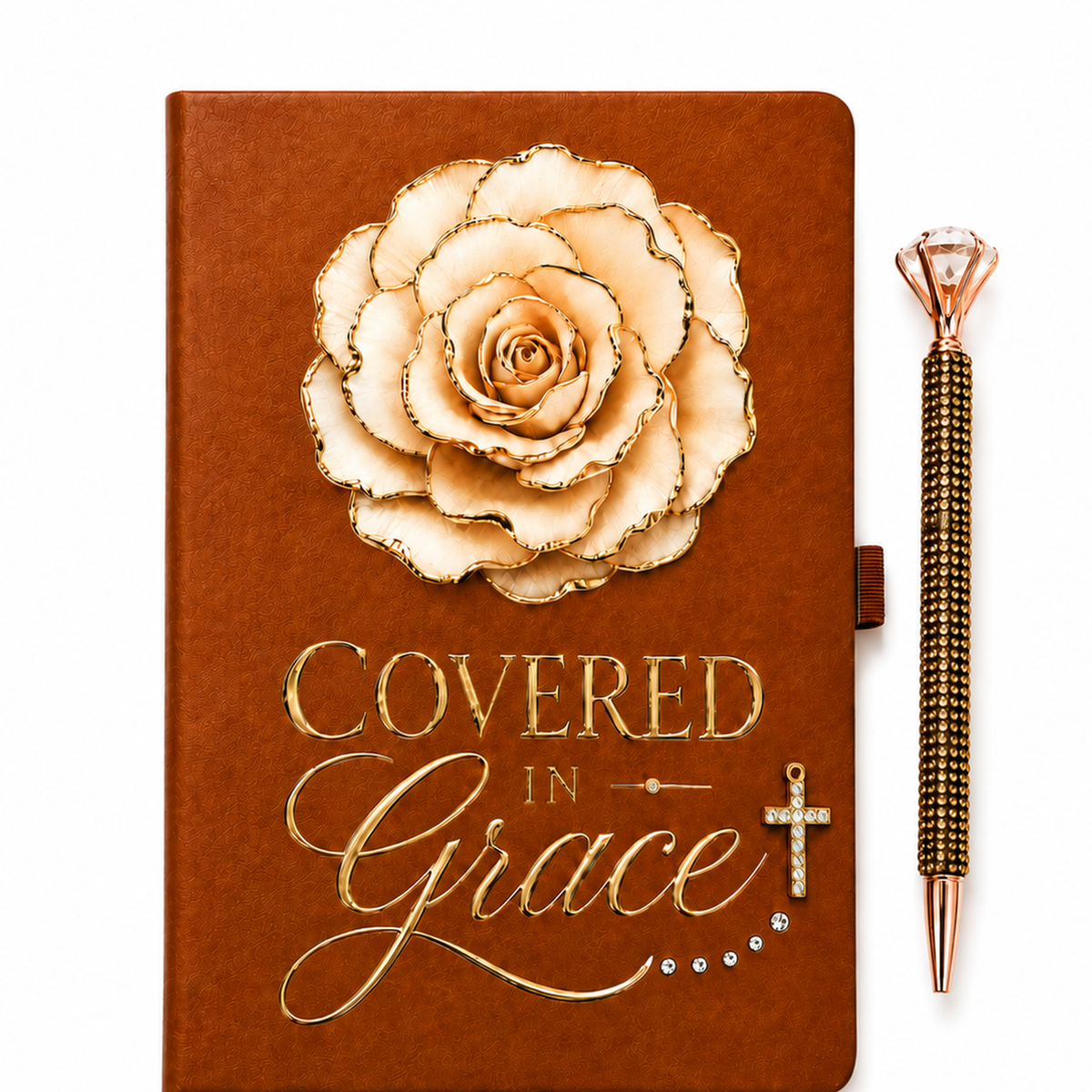 Covered in Grace journal with cognac-brown cover, cream gold-edged flower, gold lettering, crystals, and cross charm